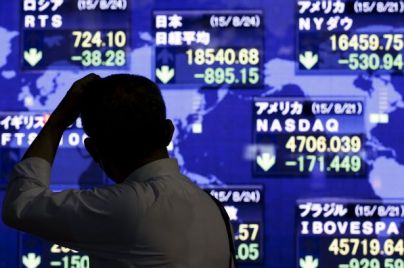 A-man-looks-at-market-indices-at-a-stock-quotation-board-outside-a-brokerage-in-Tokyo.jpg